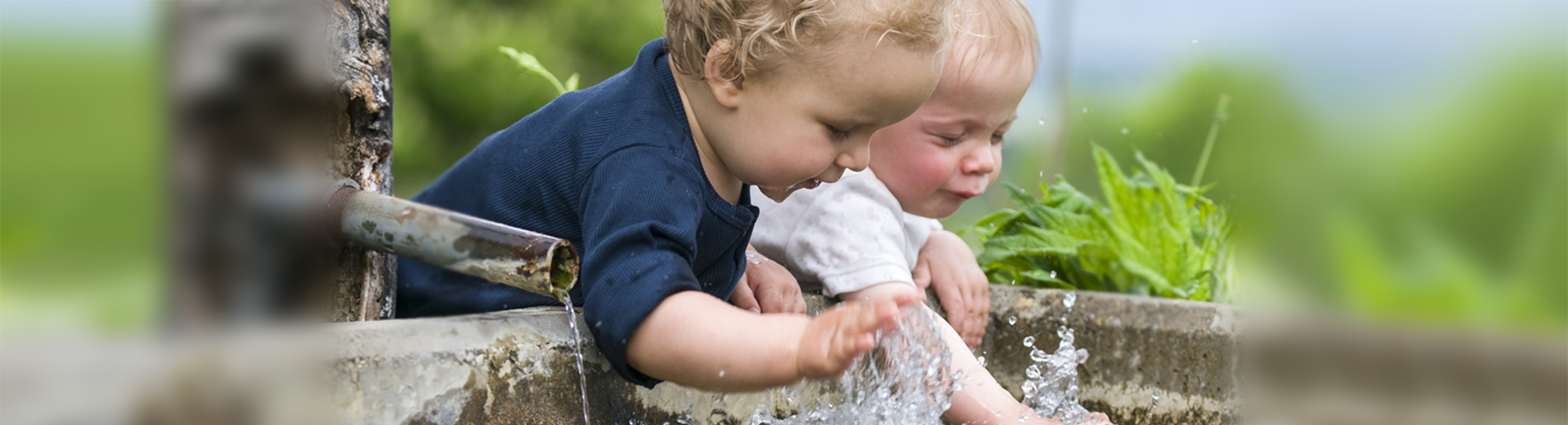 Kinder spielen in einem Brunnen